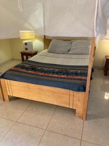 a bed in a room with a wooden frame at Chez medzo et patou in Poponguine