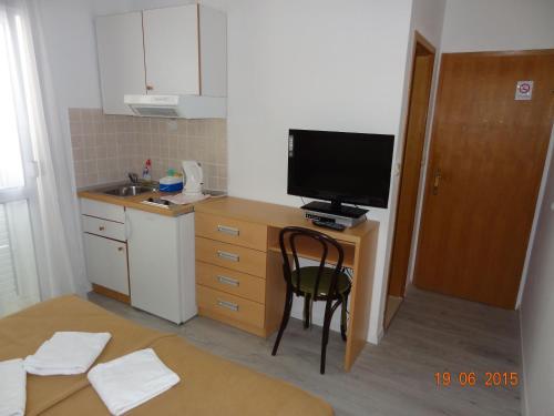 a kitchen with a desk with a tv and a chair at Komfortables Studio Apartment Mit Meerblick in Živogošće