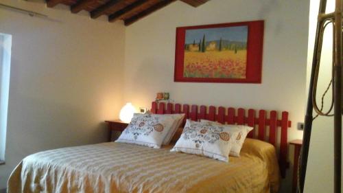 a bedroom with a bed with a red head board at Penelope in Marliana
