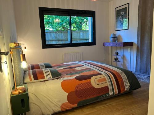 une chambre avec un lit avec une couette et une fenêtre dans l'établissement Maison charmante avec piscine, à Andernos-les-Bains