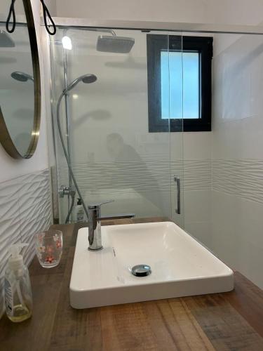 La salle de bains est pourvue d'un lavabo blanc et d'une douche. dans l'établissement Maison charmante avec piscine, à Andernos-les-Bains