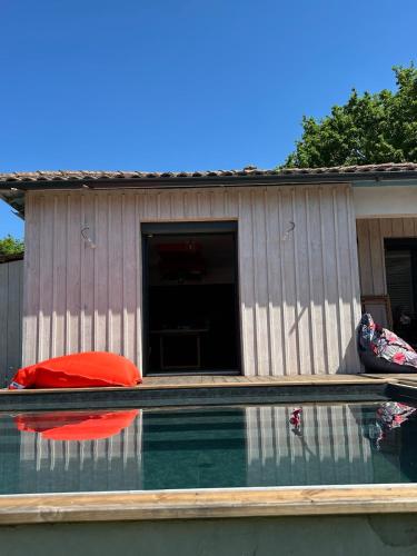 une maison avec un oreiller rouge au-dessus d'une piscine dans l'établissement Maison charmante avec piscine, à Andernos-les-Bains