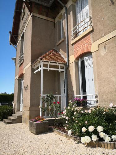 une maison avec une fenêtre et des fleurs devant elle dans l'établissement Gite La Mariette 10 couchages Brionnais Charolais, à Vauban