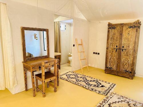 a room with a mirror and a wooden table and a mirror at Merzouga Top Luxury Camp in Merzouga