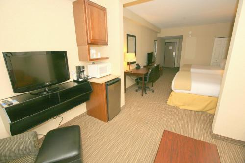 a hotel room with a bed and a flat screen tv at Holiday Inn Express San Diego South - Chula Vista by IHG in Chula Vista