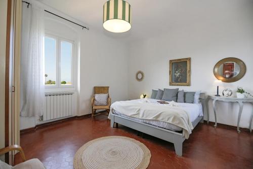a white bedroom with a bed and a window at Casa Storica a San Terenzo in San Terenzo