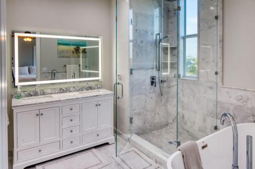 a bathroom with a shower and a sink and a mirror at Luxurious Key Largo Oceanfront 3 Bed 3 5 Bath suite in Jewfish