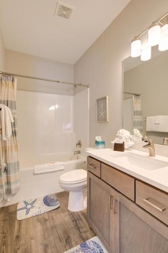 a bathroom with a sink and a toilet and a mirror at Whispering Waves Cottage in Ocean Shores