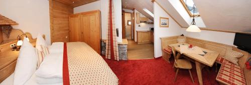 a bedroom with a bed and a table and a kitchen at Ruhige Wohnung In Sankt Gallenkirch Mit Garten in Sankt Gallenkirch
