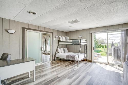 a bedroom with a bunk bed and a sliding glass door at 9 Mi to Shore Home with Hot Tub in Howards Grove! in Howards Grove