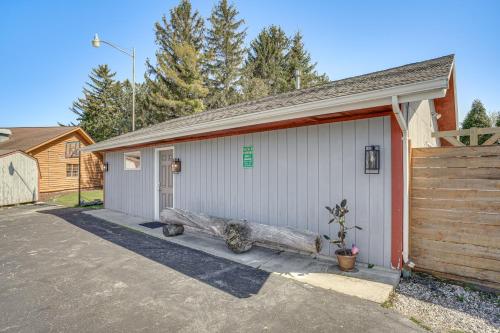 a garage with a log in front of it at 9 Mi to Shore Home with Hot Tub in Howards Grove! in Howards Grove