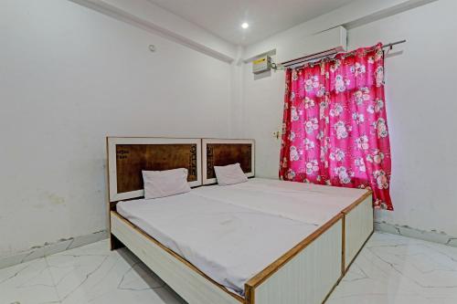 a bed in a room with a red curtain at Hotel O ONCE MORE RESTAURANT AND CAFE in Prayagraj