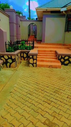 un patio con 2 bancos, una mesa y escaleras en CHALET suits, en Kampala