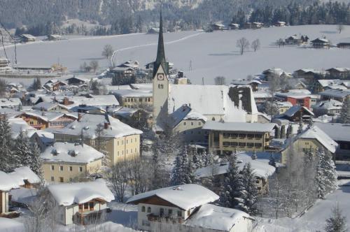 a small town covered in snow with a church at Haus Dreier in Abtenau