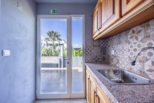 a kitchen with a sink and a door to a patio at Casa da Fonte by YOUR KEY - 1st floor house in Ribeira Brava