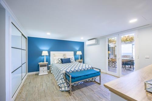 a bedroom with a bed and a blue wall at Casa da Fonte by YOUR KEY - 1st floor house in Ribeira Brava