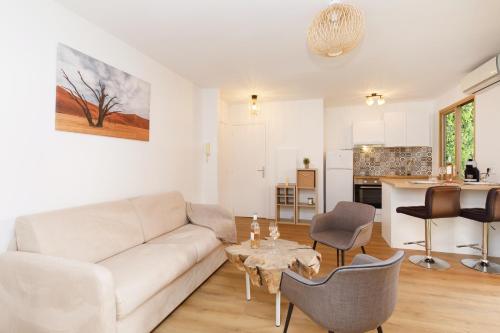 un salon avec un canapé blanc et une table dans l'établissement Plein centre, calme et lumineux, à Mandelieu-la-Napoule