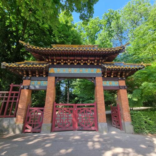 a gate in a park with a red fence at Chinese Pavilion Park - Magnificent Apartment Brussels in Brussels
