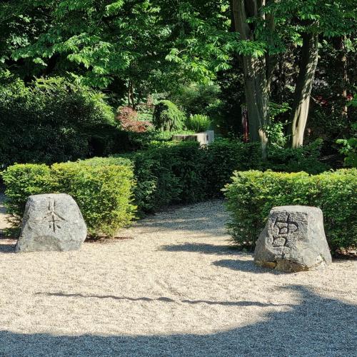 two rocks with writing on them in a garden at Chinese Pavilion Park - Magnificent Apartment Brussels in Brussels