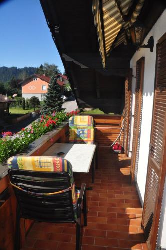 a patio with a table and chairs and flowers at Ferienwohnung Högerblick In Türnitz in Türnitz
