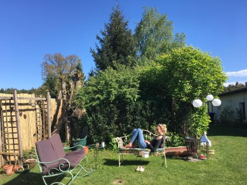 a woman sitting on a chair in a yard at Löwenzahn in Zehdenick