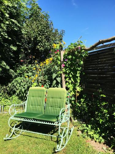 a green chair sitting in the grass in a garden at Löwenzahn in Zehdenick