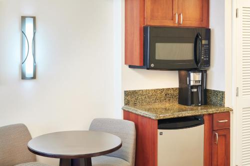 a small kitchen with a microwave and a table at Hilton Grand Vacations Club at Hilton Hawaiian Village in Honolulu