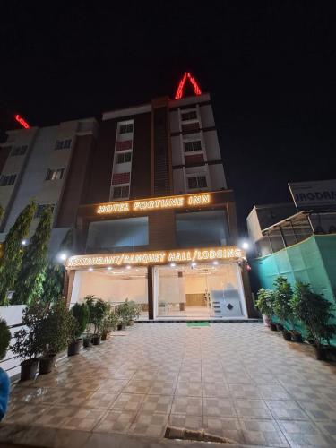 a building with a sign in front of it at night at Fortune inn Hotel and restaurant in Alandi