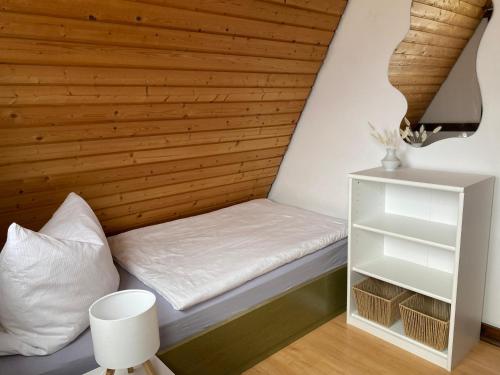 a bed in a room with a wooden wall at Ferienhaus Maria in Nagel