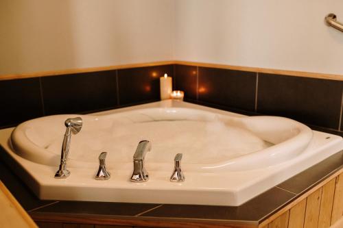 a bathroom sink with two faucets and a candle at Albert's in Shelburne