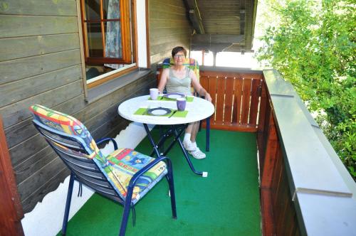 a woman sitting at a table on a porch at Gartenblick in Türnitz
