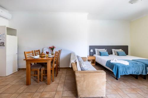 a bedroom with a bed and a table and a dining room at Montinhos Nature Stay in Luz