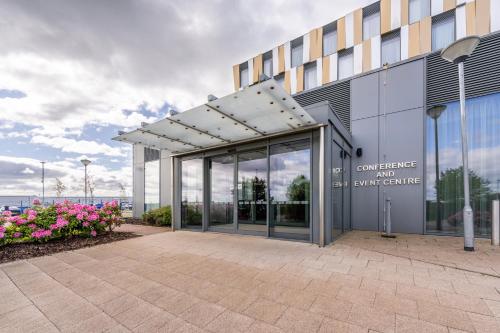 an entrance to a building with flowers in front of it at Crowne Plaza Aberdeen Airport by IHG in Dyce