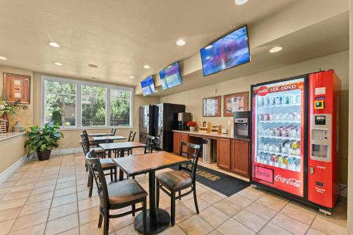 a restaurant with tables and chairs and a soda machine at New Trendy 1BR Apartment with Heated Pool Gym & Minigolf in Reno