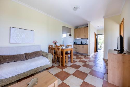 a living room with a couch and a table at Montinhos Nature Stay in Luz