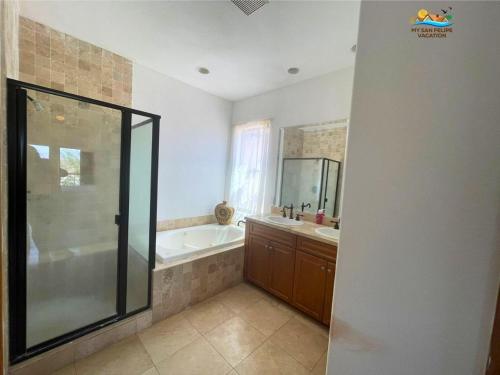 a bathroom with a shower and a tub and a sink at San Felipe Luxurious 3-Bedroom Condo 11-3 with Pool Access in Playa El Paraíso