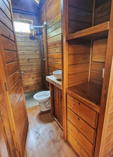 a wooden bathroom with a toilet and a sink at Natural Harmony Bungalow in Baturité