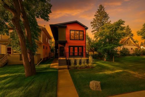 a small house with a tree in a yard at Chic Hideaway-King Bed-Fireplace-DT-WEM-Garage in Edmonton