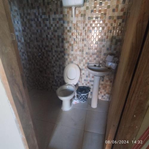 a small bathroom with a toilet and a sink at Chalet ULI in Luque