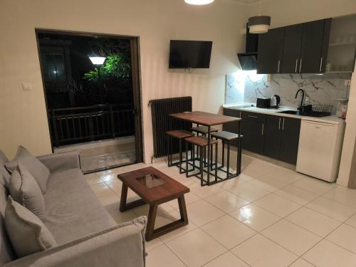 a living room with a couch and a table and a kitchen at Samothraki Echo Apartment in Alexandroupoli