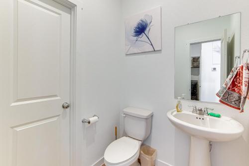 a white bathroom with a toilet and a sink at 8 Mi to Celebration Station Family Getaway! in Mesquite