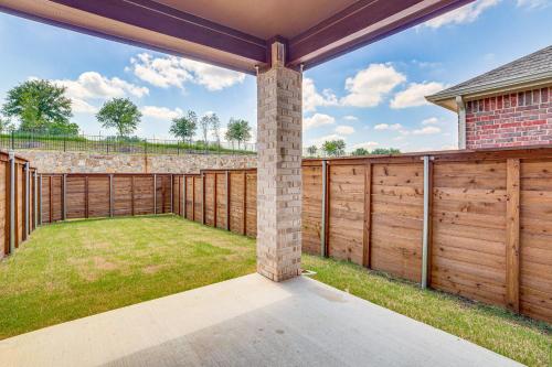 an outdoor patio with a wooden fence and grass at 8 Mi to Celebration Station Family Getaway! in Mesquite