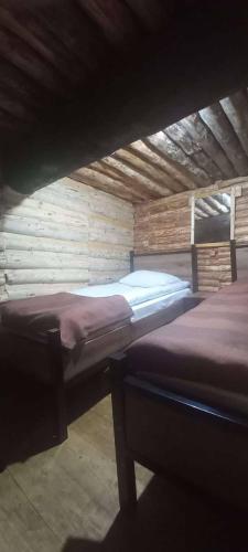 a room with two beds in a wooden building at Hotel Front Castle in Shatili