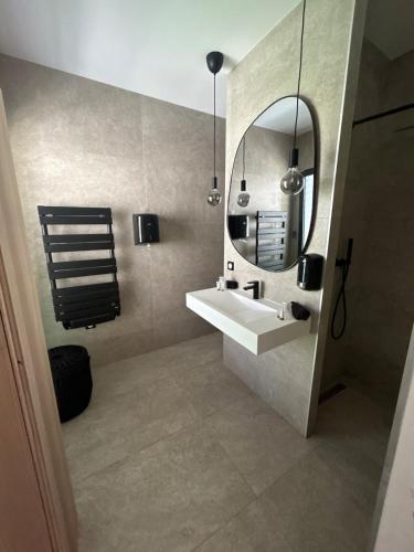 une salle de bain avec un lavabo et un miroir dans l'établissement Villa Palmeraie 240m2 Piscine Jacuzzi, à Lieuran-lès-Béziers