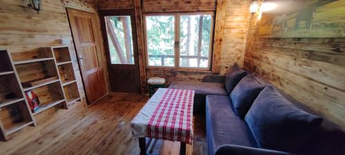 a living room with a couch in a log cabin at Vajat 2 - Zlatarsko jezero in Goronjići