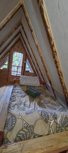 a large bed in a room with a roof at Vajat 2 - Zlatarsko jezero in Goronjići