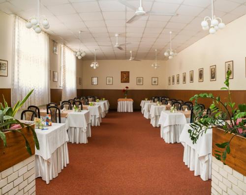 a row of tables in a banquet hall with white linens at Ensana Pro Patria in Piešťany