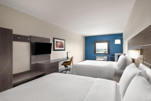 a hotel room with two beds and a television at Holiday Inn Express & Suites Boynton Beach West by IHG in Boynton Beach