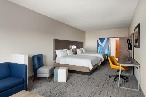 a hotel room with a bed and a desk and chair at Holiday Inn Express & Suites Boynton Beach West by IHG in Boynton Beach