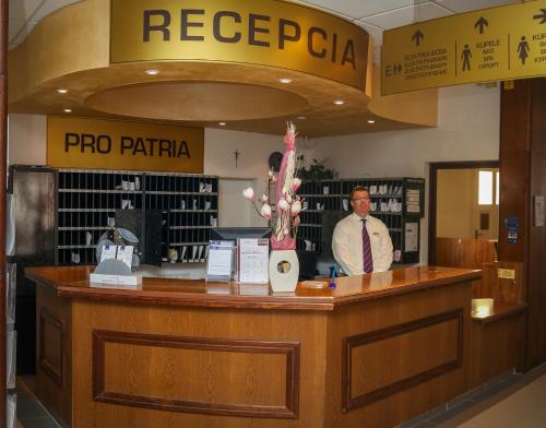 a man standing at the counter of a poco parita store at Ensana Pro Patria in Piešťany